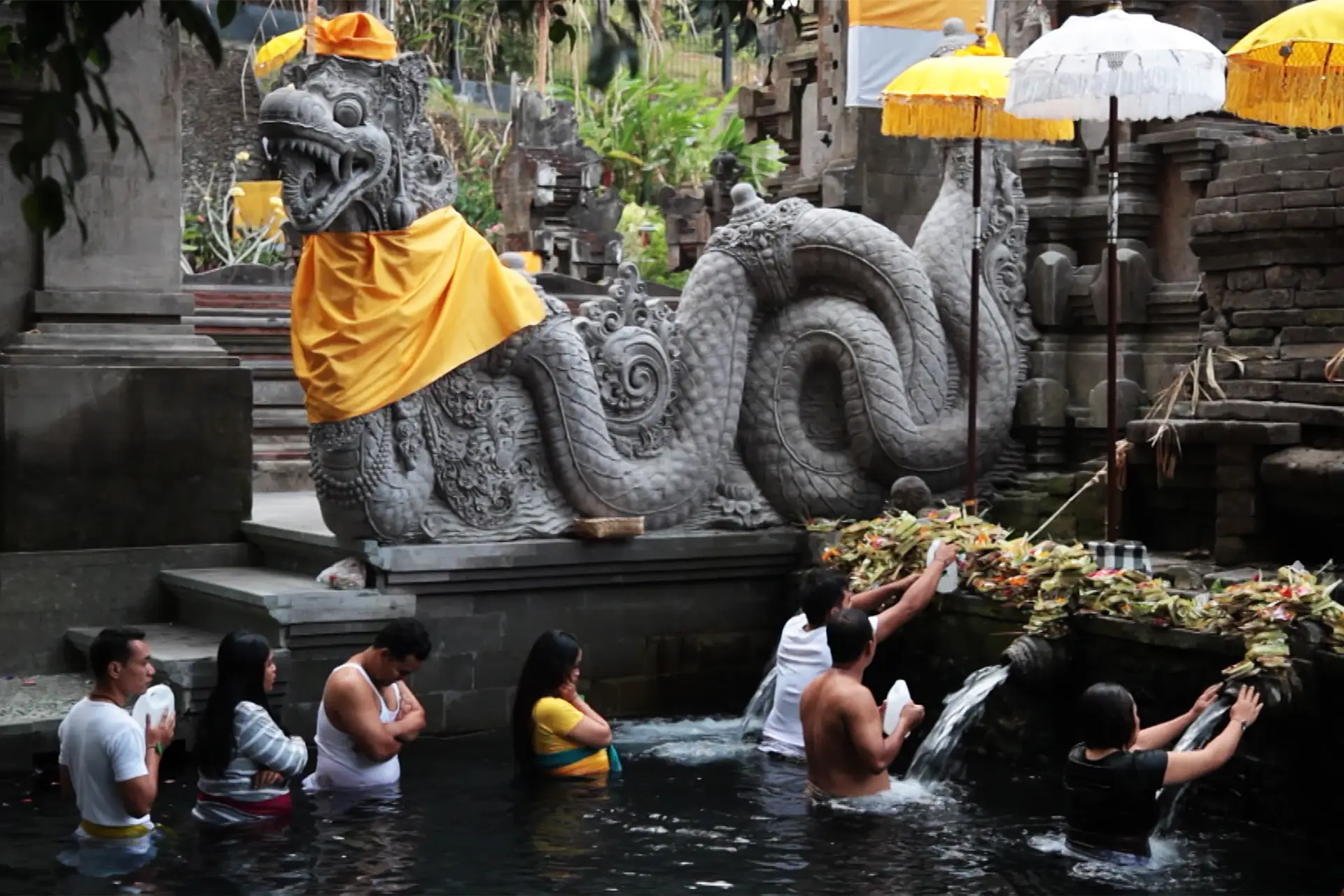 Personas bañándose en las fuentes sagradas del templo de Tirta Empul - viaje organizado a Bali