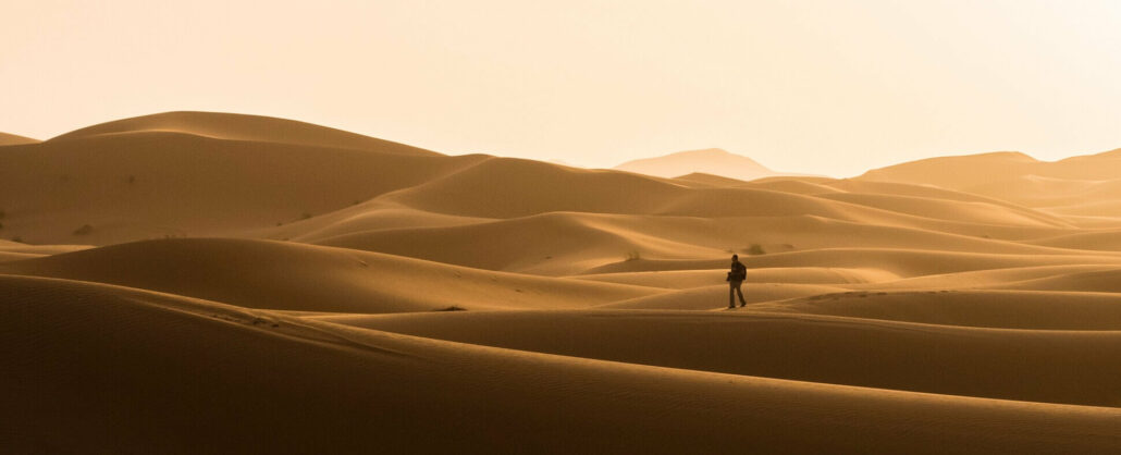 Silueta de viajero paseando sobre las dunas