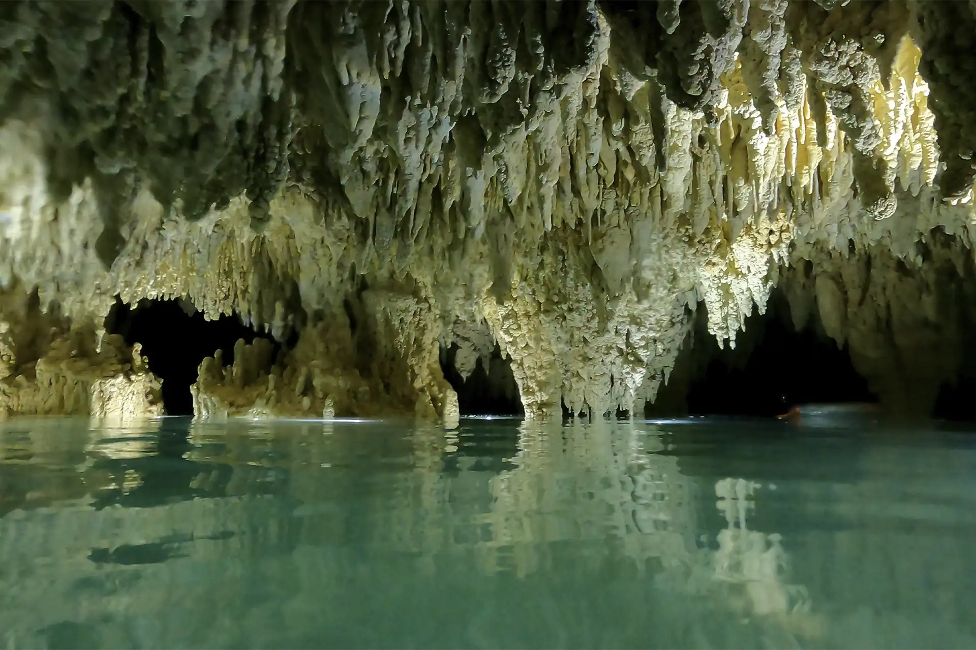 Interior de un cenote cueva con estalactitas y estalagmitas