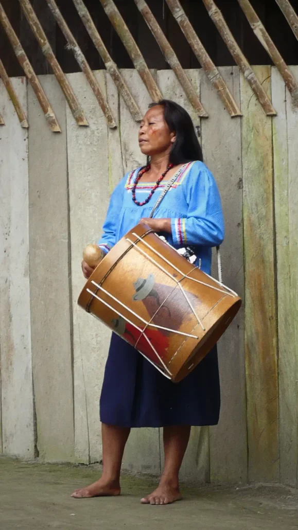 Mujer indígena tocando el tambor en la comunidad de Shiripuno, Ecuador