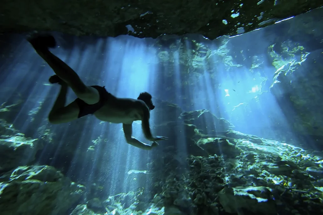 Viajero buceando en un cenote en Riviera Maya de manera sostenible