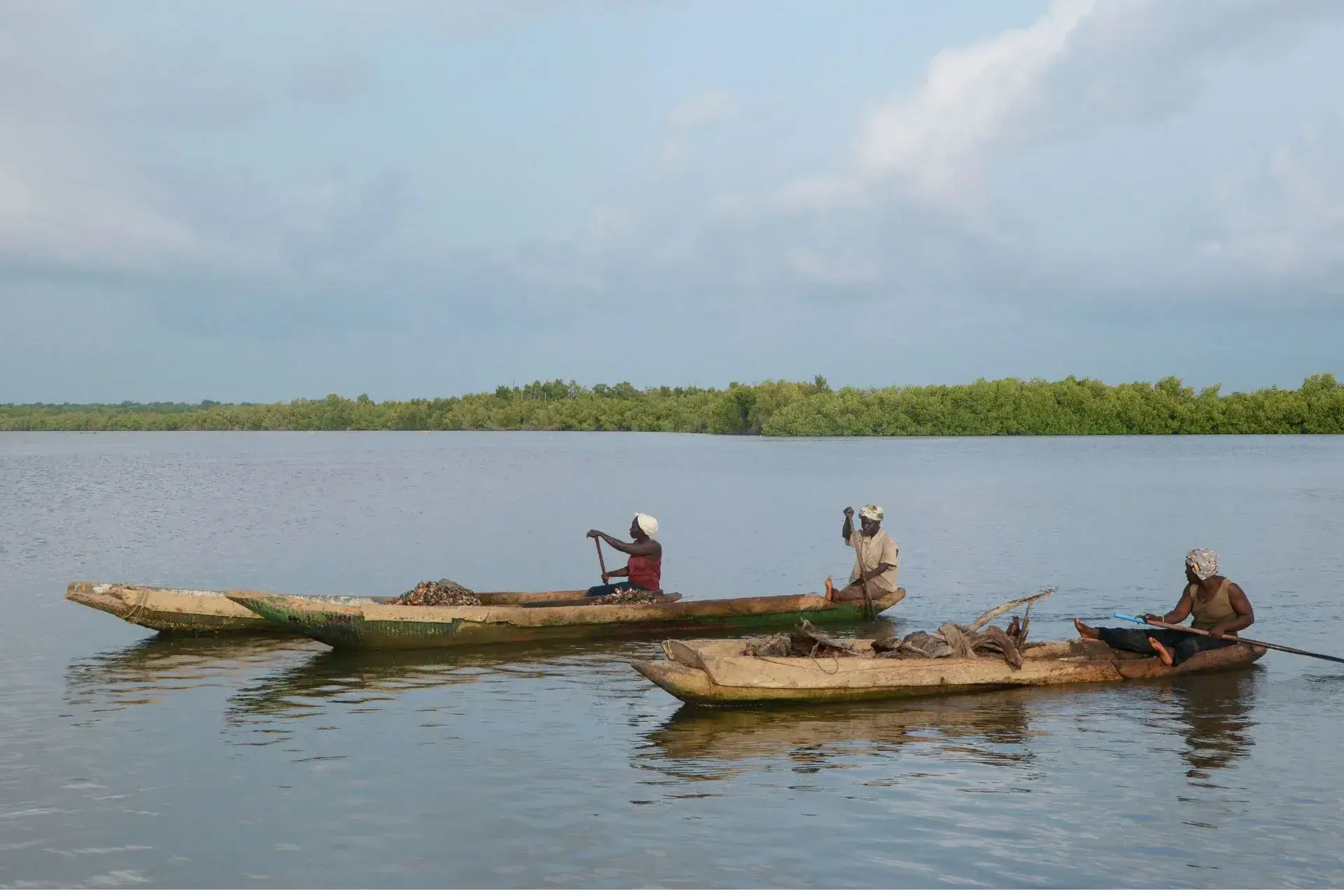 Dos canoas y tres pescadores navegando por el Delta del Casamance