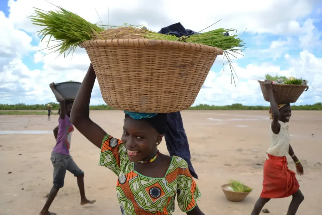 Mujeres sonriendo con cestas sobre la cabeza. Tour para viajar a Senegal con niños