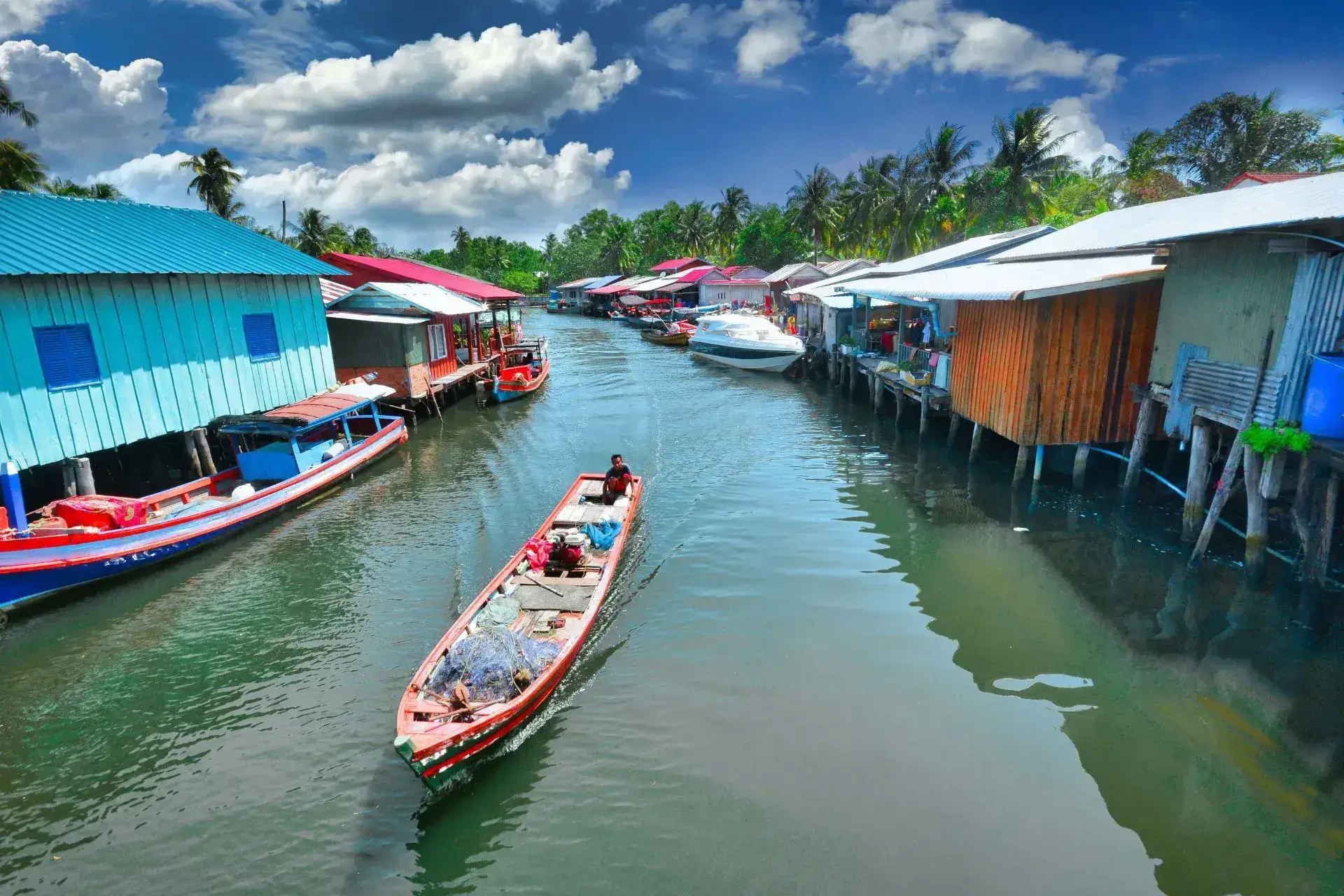 Casas de colores sobre el agua y una canoa navegando por el medio del canal