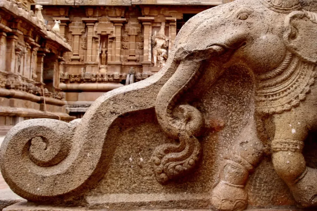 Detalle de un elefante esculpido en piedra con la trompa extendida