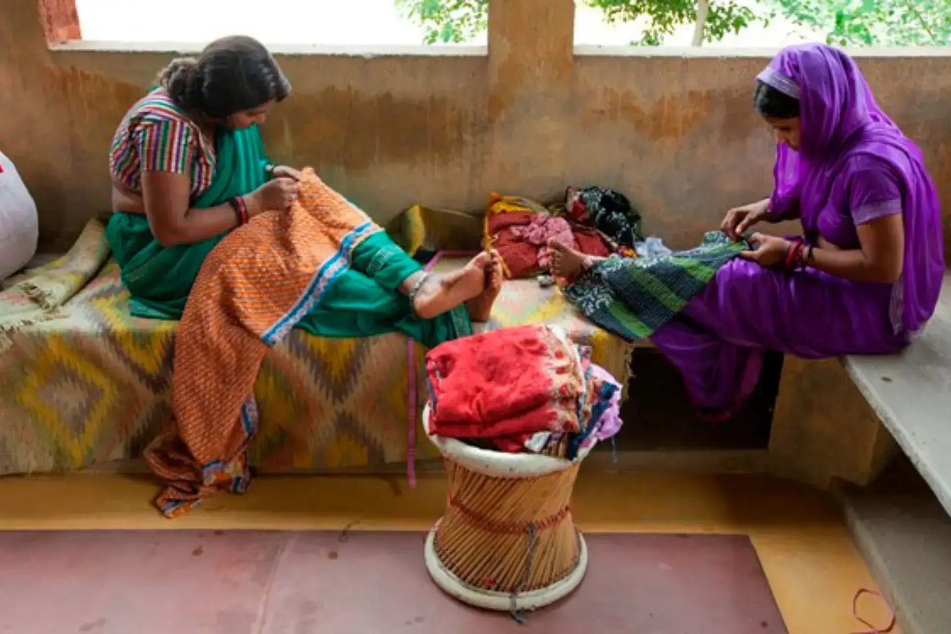 Dos mujeres indias sentadas y cosiendo