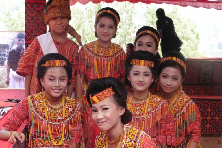 Varias mujeres y un hombre asiáticos con trajes tradicionales