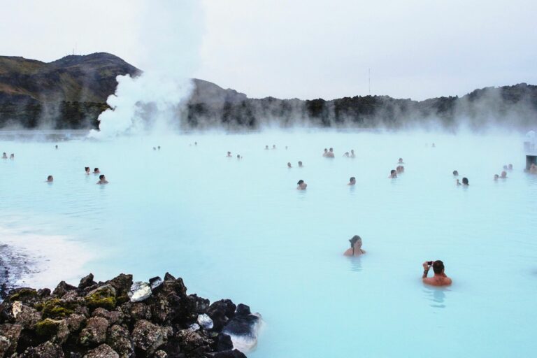 Personas bañándose en aguas azules que desprenden humo