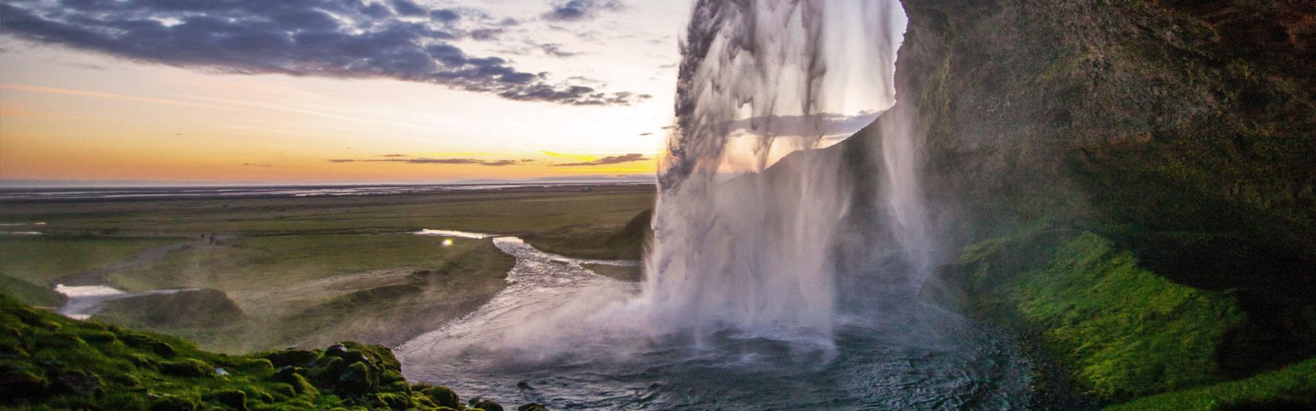 Paisaje al atardecer con una cascada de agua cayendo