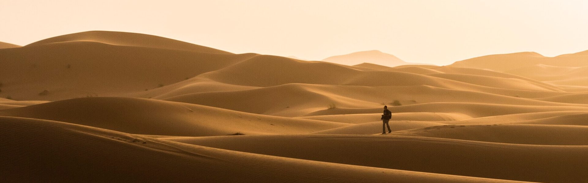 Silueta de viajero paseando sobre las dunas